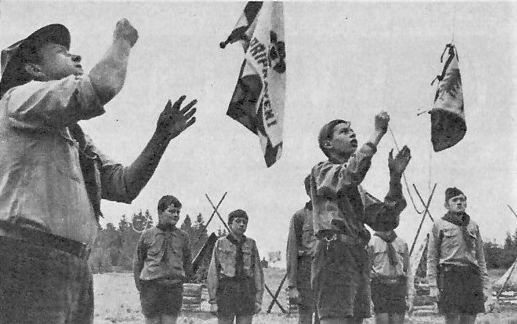 1968, z tábora Jedničky v Matějovci u Dačic. Oddílovou vlajku vztyčuje Bobr, družinovou Delf. Časopis Junák 3-4/1968